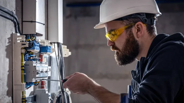 Técnico conectando protecciones en un tablero eléctrico